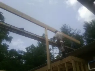 Carpenter setting a ridge beam over a new addition frame — Ice Dam Removal by Roofing Brothers in Edgemoor