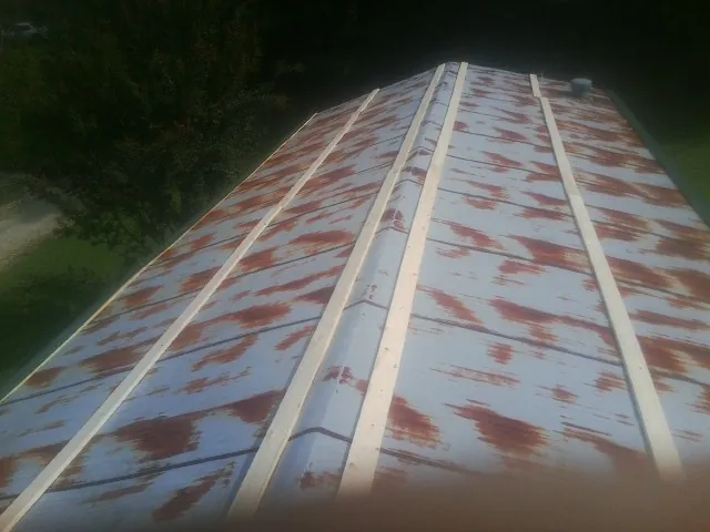 Rusted metal roof panels with new wood purlins before replacement — Storm Damage Roof Repair in Edgemoor by Roofing Brothers